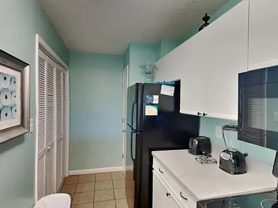 a kitchen with a black refrigerator in a room at Edgewater Villa 1501 in Panama City Beach