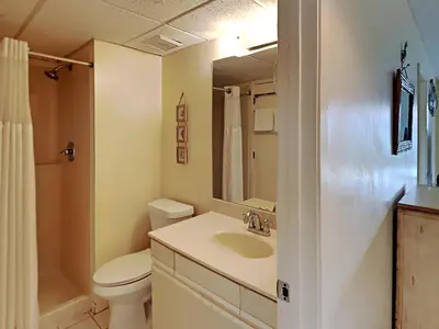 a bathroom with a sink and a toilet and a mirror at Edgewater Villa #2505 in Panama City Beach