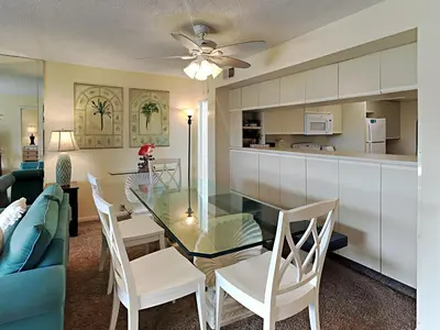 a dining room and kitchen with a glass table and chairs at Edgewater Villa #2505 in Panama City Beach