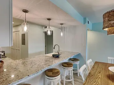 a kitchen with a sink and a counter with stools at Edgewater Villa #2505 in Panama City Beach