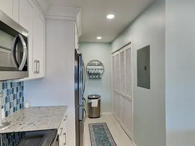 a kitchen with white walls and a refrigerator at Edgewater Villa #2505 in Panama City Beach
