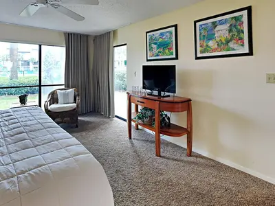 a bedroom with a bed and a desk with a television at Edgewater Villa #2505 in Panama City Beach