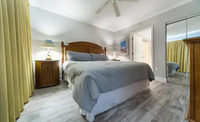 a bedroom with a large bed and a mirror at Emerald Beach #2535 in Panama City Beach