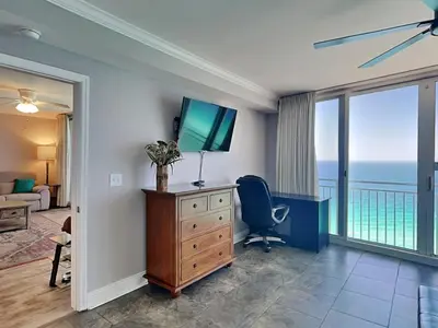 a room with a desk with a television and a window at Emerald Beach #2535 in Panama City Beach