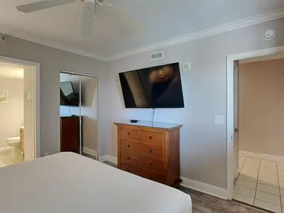 a bedroom with a bed and a television on a wall at Emerald Beach #2535 in Panama City Beach