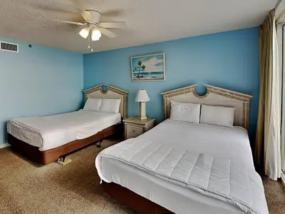 two beds in a bedroom with blue walls at Long Beach Resort Tower II #306 in Panama City Beach