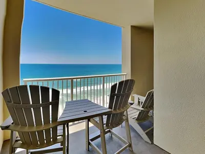 a table and chairs on a balcony with a view of the ocean at Grand Panama Beach Resort - The Grand #1304 in Panama City Beach