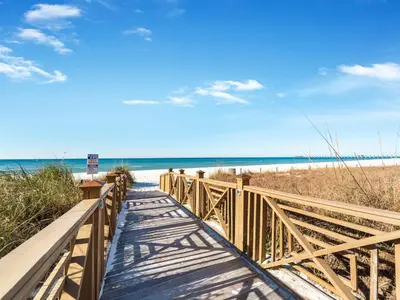 a wooden walkway to the beach with the ocean at Grand Panama Beach Resort - The Grand #1304 in Panama City Beach