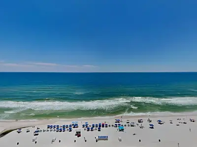 a beach with chairs and umbrellas and the ocean at Grand Panama Beach Resort - The Grand #1304 in Panama City Beach