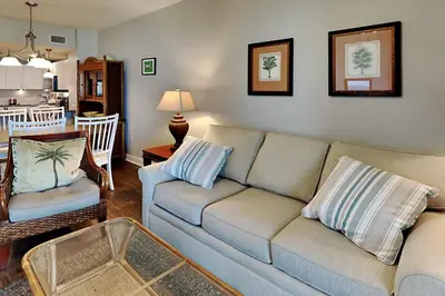 a living room with a couch and a table at Grand Panama Beach Resort - The Grand #403 in Panama City Beach