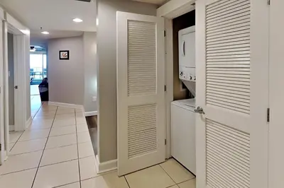 a hallway with white doors and a laundry room at Grand Panama Beach Resort - The Grand #403 in Panama City Beach
