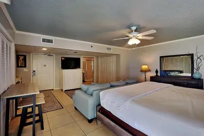 a bedroom with a bed and a couch and a table at Long Beach Resort Tower I #900E in Panama City Beach