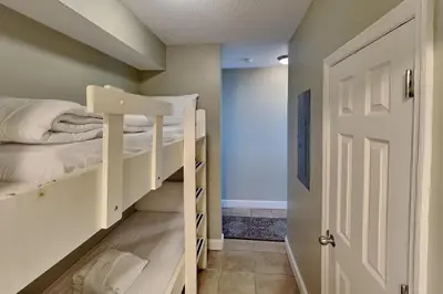 a room with two bunk beds and a door at Majestic Beach Towers I #1608 in Panama City Beach
