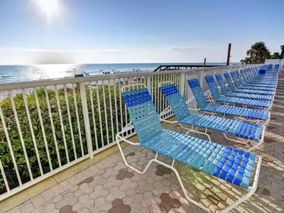 a row of blue chairs sitting next to the beach at Majestic Beach Towers I #1608 in Panama City Beach