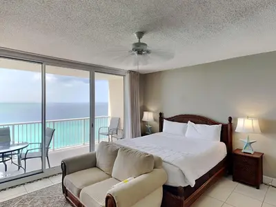 a bedroom with a bed and a couch and a balcony at Majestic Beach Towers I #1608 in Panama City Beach
