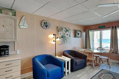a living room with two blue chairs and a table at Continental 319 in Panama City Beach