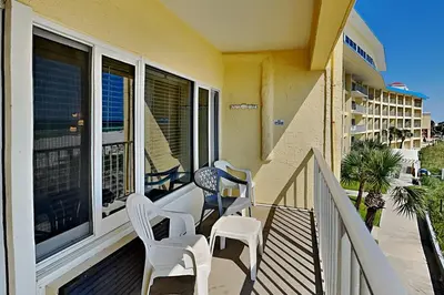 a porch with white chairs and a balcony with a view at Continental 319 in Panama City Beach