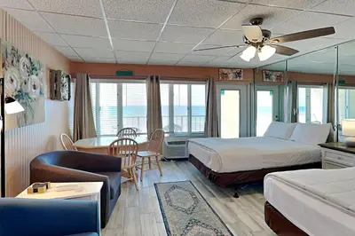 a hotel room with a bed and a living room at Continental 319 in Panama City Beach