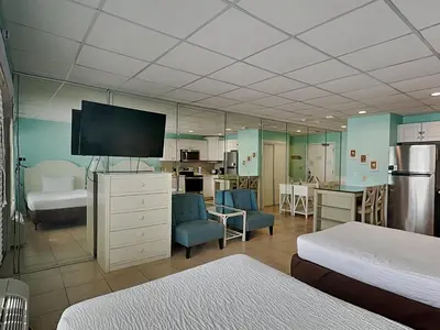 a large room with a bedroom with a large mirror at Continental 419 in Panama City Beach
