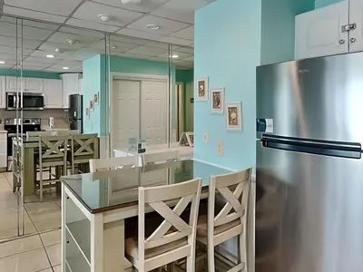 a kitchen with a refrigerator and a table and chairs at Continental 419 in Panama City Beach