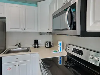 a kitchen with a sink and a microwave at Continental 419 in Panama City Beach