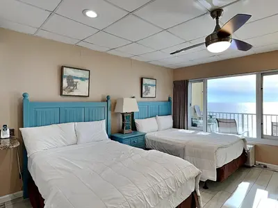 a bedroom with two beds and a balcony at Continental 503 in Panama City Beach