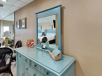 a blue dresser with a mirror in a bedroom at Continental 503 in Panama City Beach