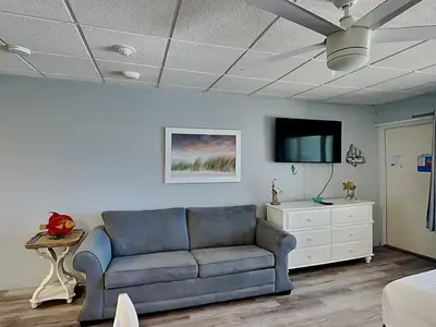 a living room with a blue couch and a tv at Continental Condominiums 3 in Panama City Beach