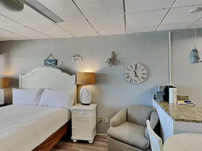 a bedroom with a bed and a chair and a clock at Continental Condominiums 3 in Panama City Beach