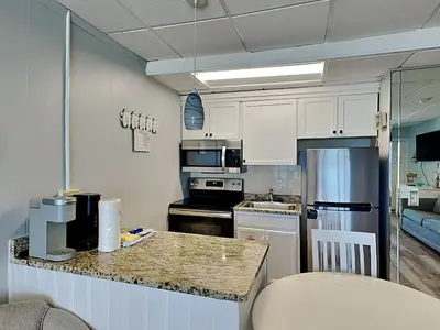a small kitchen with white cabinets and a counter top at Continental Condominiums 3 in Panama City Beach