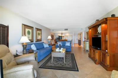 a living room with a blue couch and a tv at Edgewater Tower I 704 in Panama City Beach