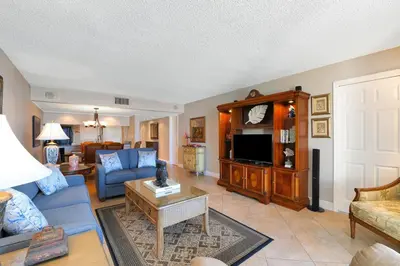 a living room with a blue couch and a tv at Edgewater Tower I 704 in Panama City Beach