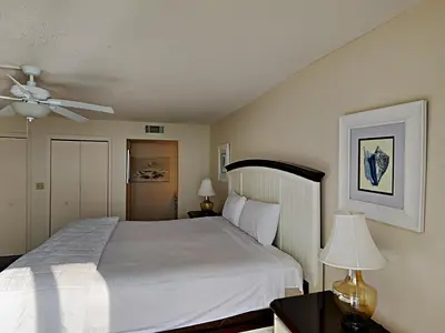 a bedroom with a white bed and a ceiling fan at Edgewater Tower I 904 in Panama City Beach