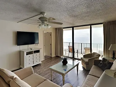 a living room with a couch and a flat screen tv at Edgewater Tower I 904 in Panama City Beach