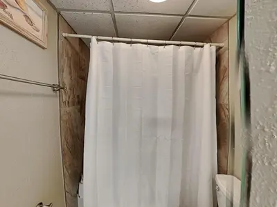 a white shower curtain in a bathroom with a toilet at Edgewater Tower II #204 in Panama City Beach