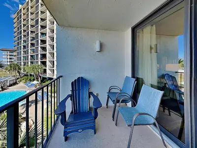 a balcony with blue chairs and a swimming pool at Edgewater Tower II #204 in Panama City Beach