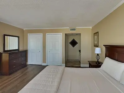 a large bedroom with a large bed and two doors at Edgewater Tower Ii 504 in Panama City Beach
