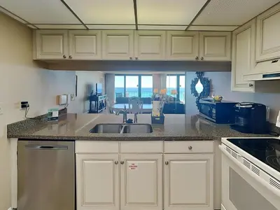 a kitchen with a sink and a view of the ocean at Edgewater Tower Ii 504 in Panama City Beach