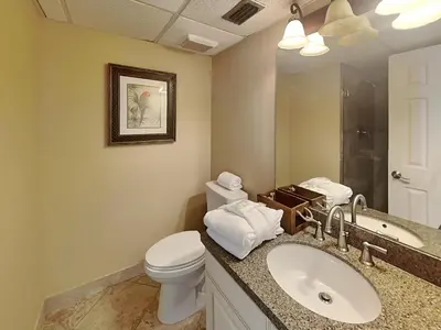 a bathroom with a toilet and a sink and a mirror at Edgewater Tower Ii 504 in Panama City Beach