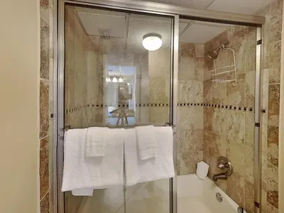 a bathroom with a shower and a bath tub with towels at Edgewater Tower Ii 504 in Panama City Beach