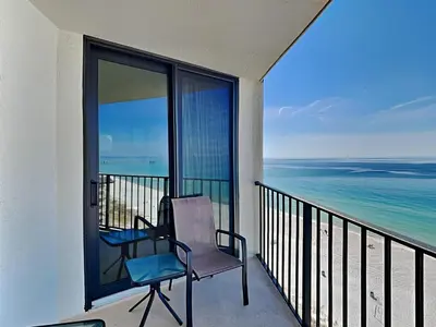 a chair on a balcony with a view of the ocean at Edgewater Tower II 1004 in Panama City Beach