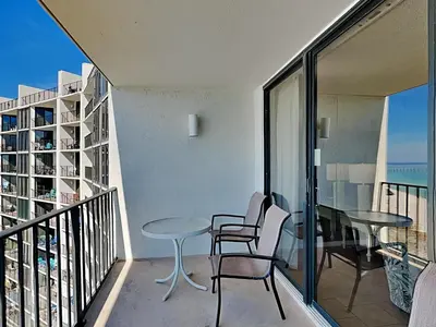 a balcony with a table and chairs and a view of the ocean at Edgewater Tower II 1004 in Panama City Beach