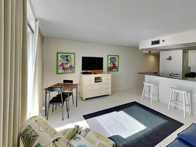 a living room with a couch and a table and a kitchen at Edgewater Tower III #608 in Panama City Beach