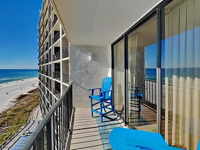 a balcony with two blue chairs and the beach at Edgewater Tower III #608 in Panama City Beach