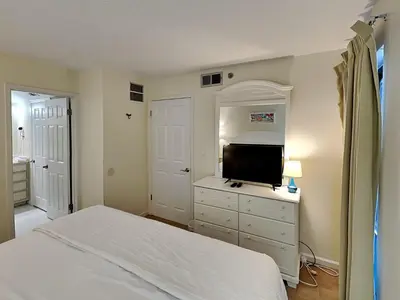 a bedroom with a bed and a flat screen tv at Edgewater Tower III #608 in Panama City Beach