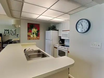 a kitchen with a sink and a clock on the wall at Edgewater Tower III #609 in Panama City Beach