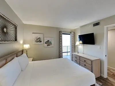 a bedroom with a white bed and a television at Edgewater Tower III #609 in Panama City Beach