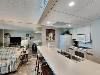a kitchen and living room with a couch and a counter at Edgewater Tower III #609 in Panama City Beach