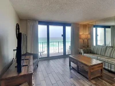 a living room with a couch and a table with a television at Edgewater Tower III #609 in Panama City Beach