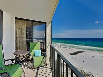 a balcony with chairs and a table and the beach at Edgewater Tower III #704 in Panama City Beach
